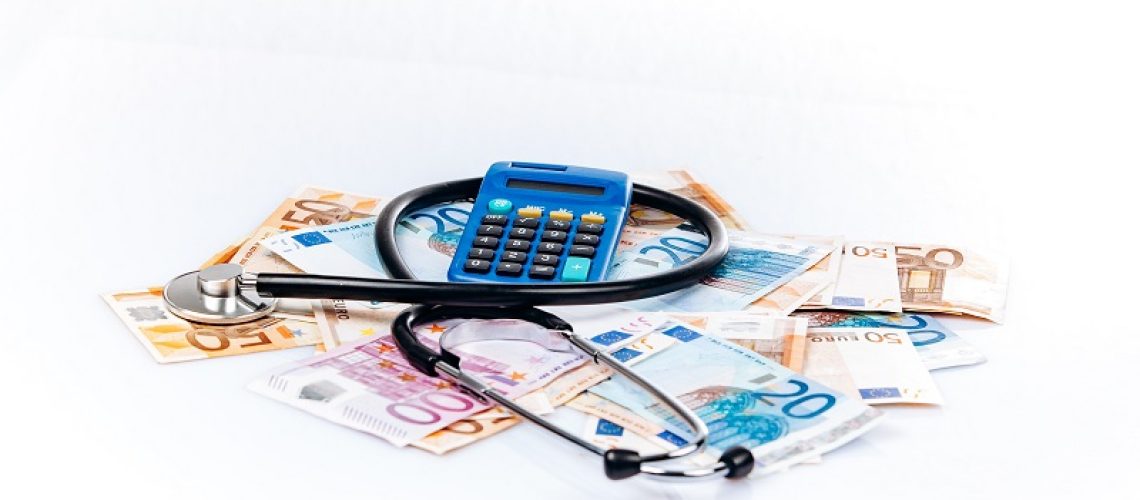 health care concept with calculator, money and stethoscope on white background