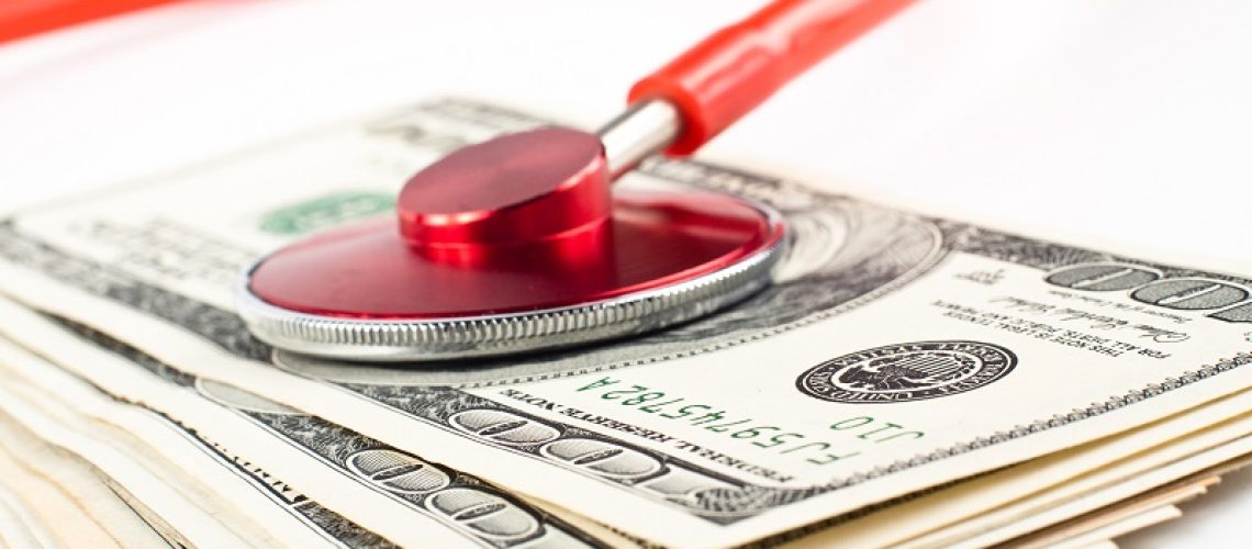 dollars cosulted with a red stethoscope close-up on white background